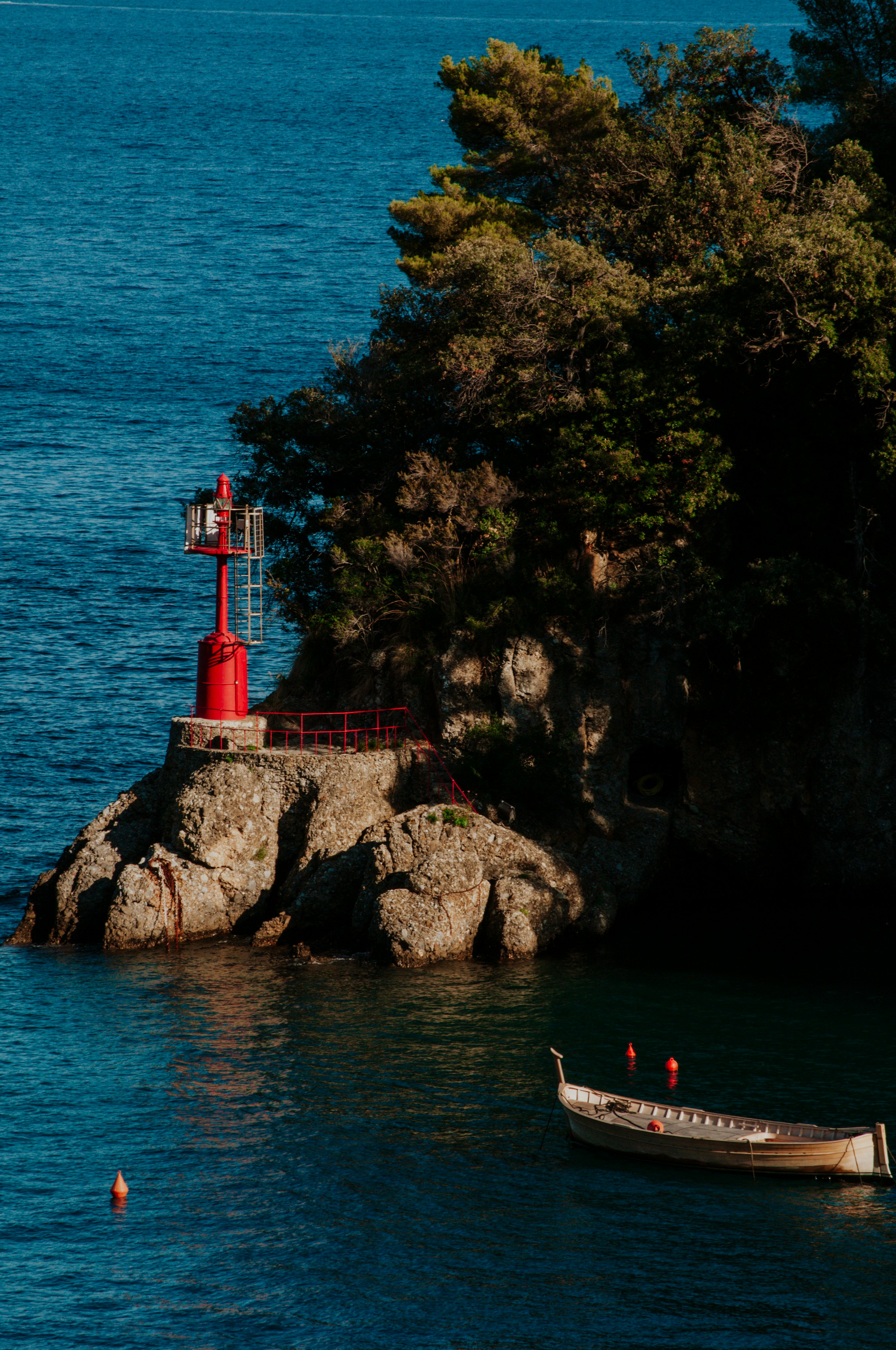 people on a rocky beach with a red tower in the distance